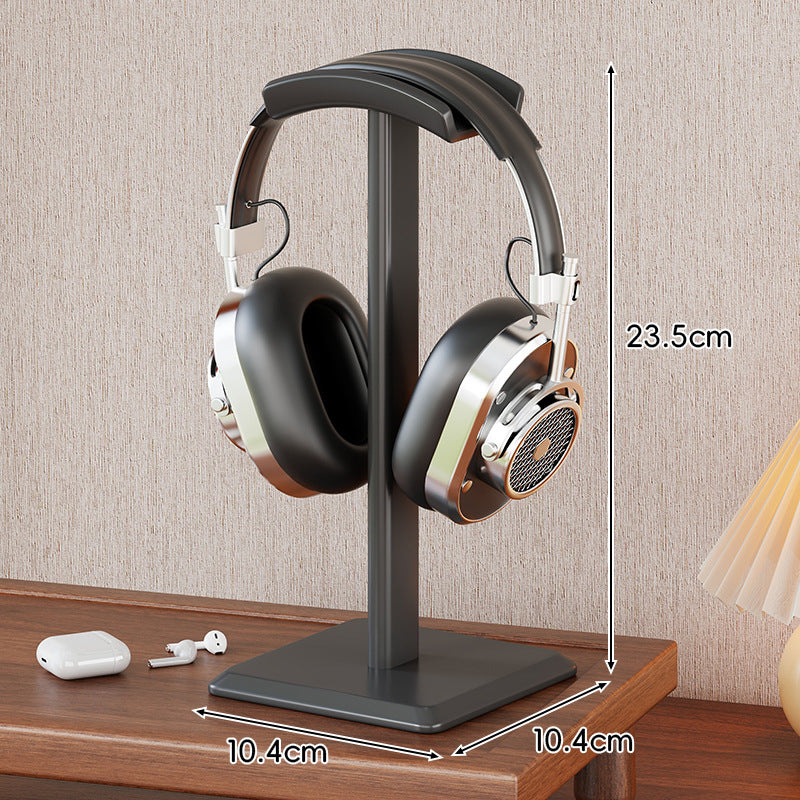Headphone stand holding a pair of headphones with measurements indicated on a wooden surface.